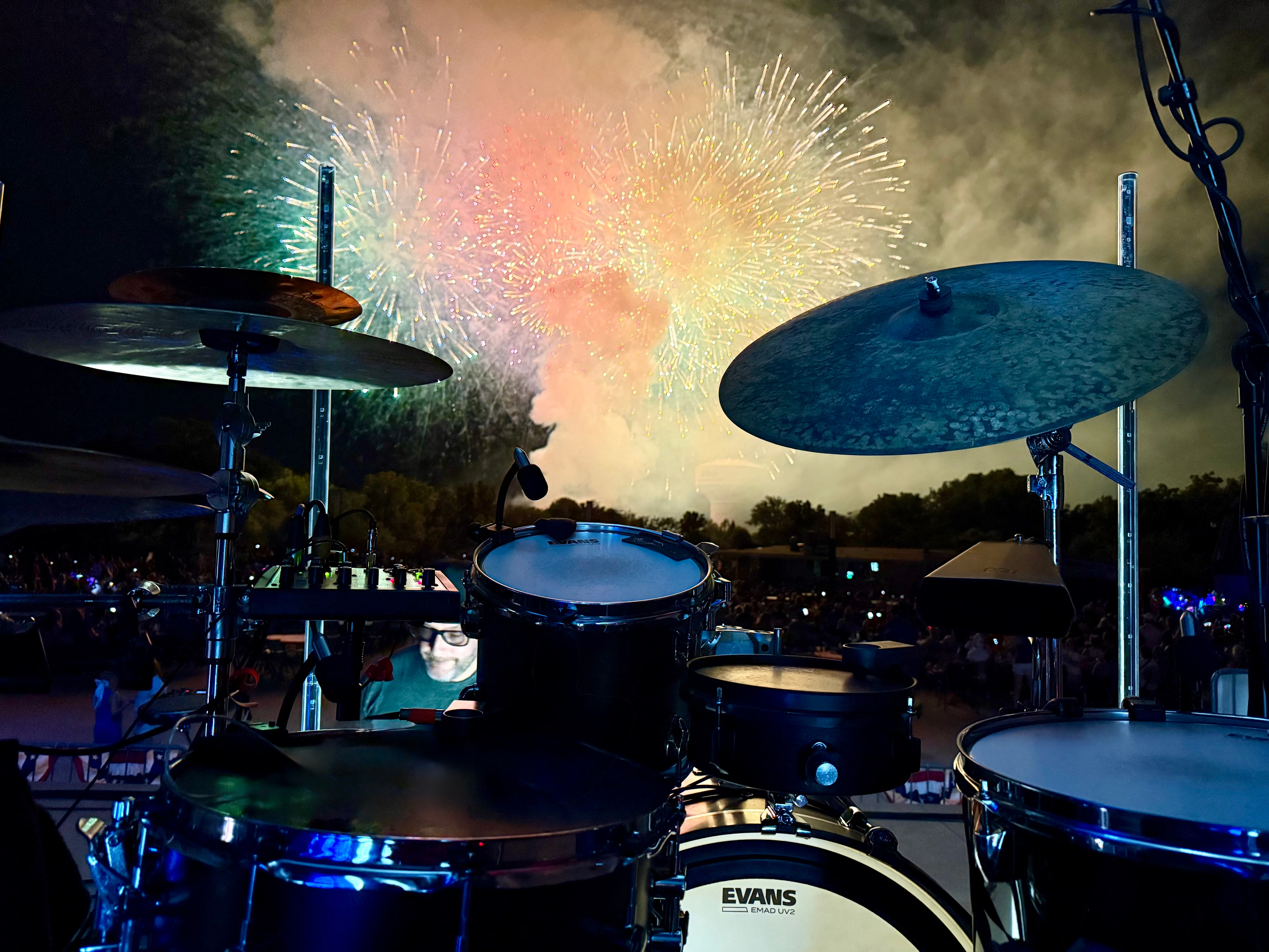 Scott Hafferkamp performing at a drum kit beneath fireworks